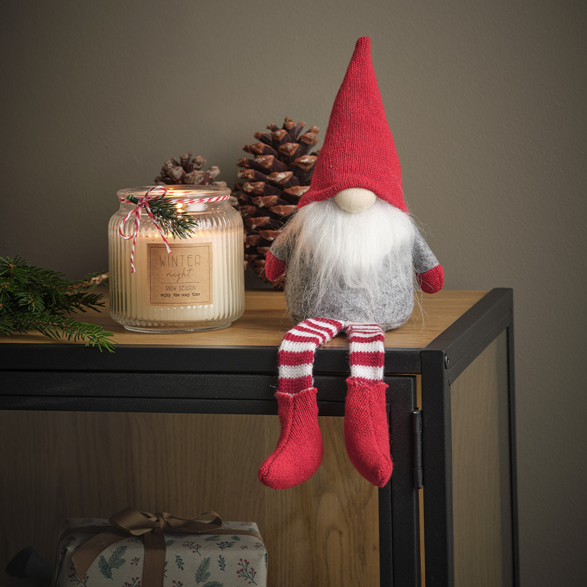 Božićni vilenjak s bijelom bradom, crvenom kapom i crveno-bijelim čarapama