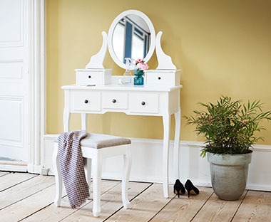 Bijeli toaletni stolić s ogledalom, tegom i biljkom i stolicom