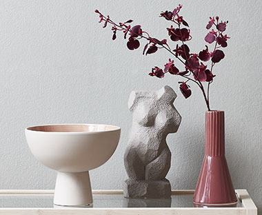 Zdjela, statua i vaza s umjetnim cvijećem