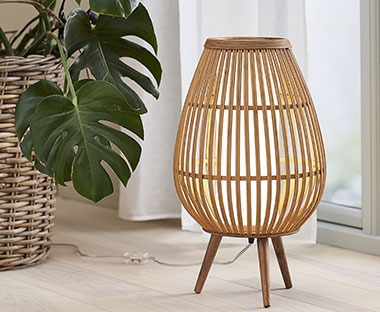 Podna lampa od bambusa na podu kraj biljke