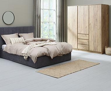 Ormar s izgledom drva i tapecirani krevet u sobi
