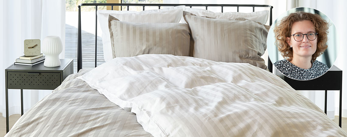 Spavaća soba s krevetom, poplunima i jastucima, prekrivena prugastom posteljinom i Berit Christiansen