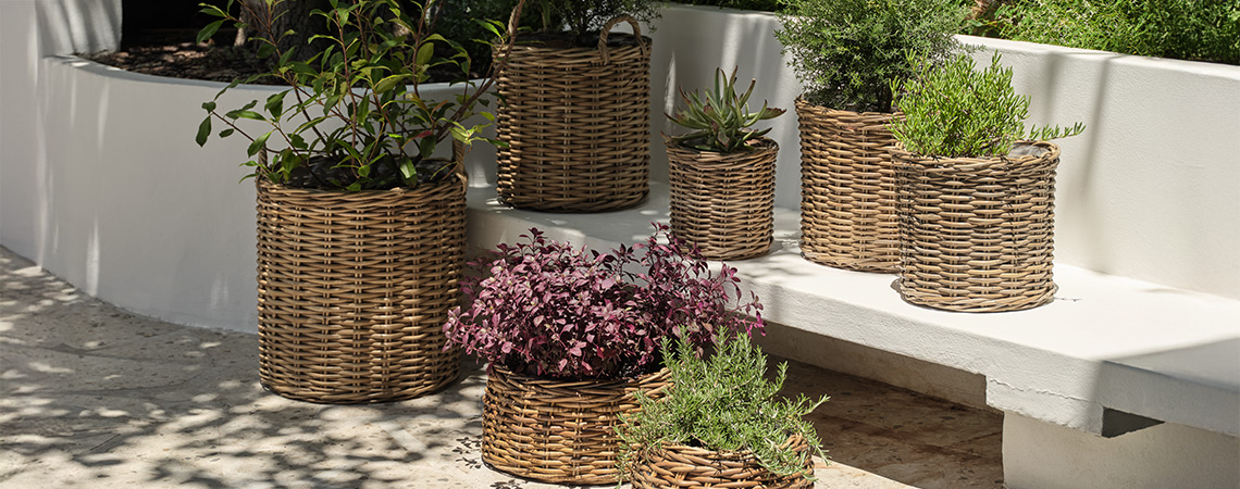 Vrtne žardinjere i vrtne posude od ratana u svijetlom vrtu