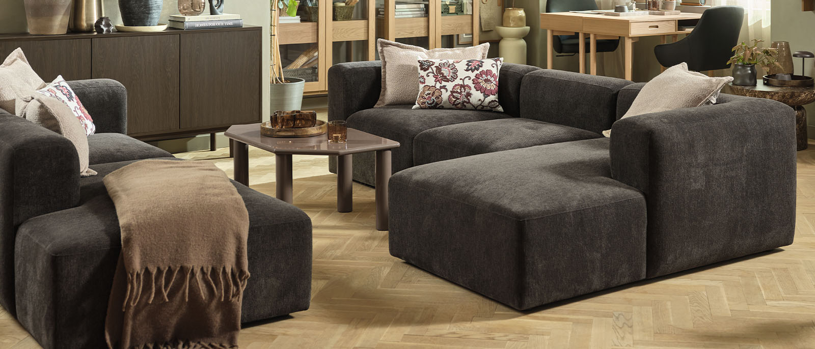 Saznajte više o tome zašto je modularna sofa odličan izbor za vaš dom Tamnosmeđa modularna kutna garnitura u velikom rasporedu za sjedenje u dnevnom boravku