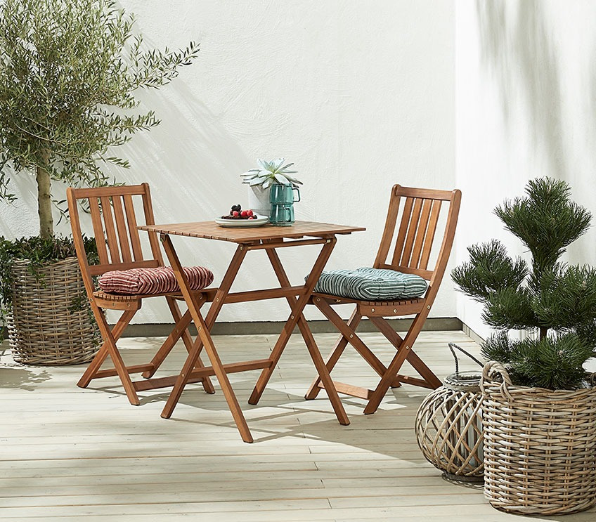 Vrtni set koji se sastoji od stola i 2 stolice na drvenoj terasi
