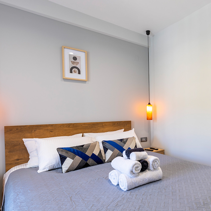 Furnished bedroom with bed, bedNamještena spavaća soba s krevetom, posteljinom i ručnicima sheets and towels
