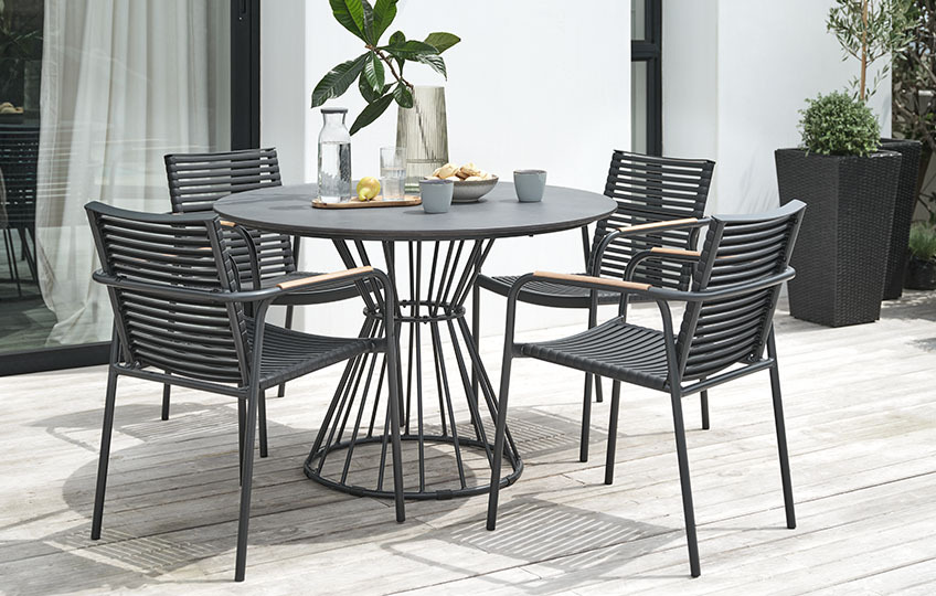 Okrugli vrtni stol s površinom od vlaknastog cementa i plastične vrtne stolice