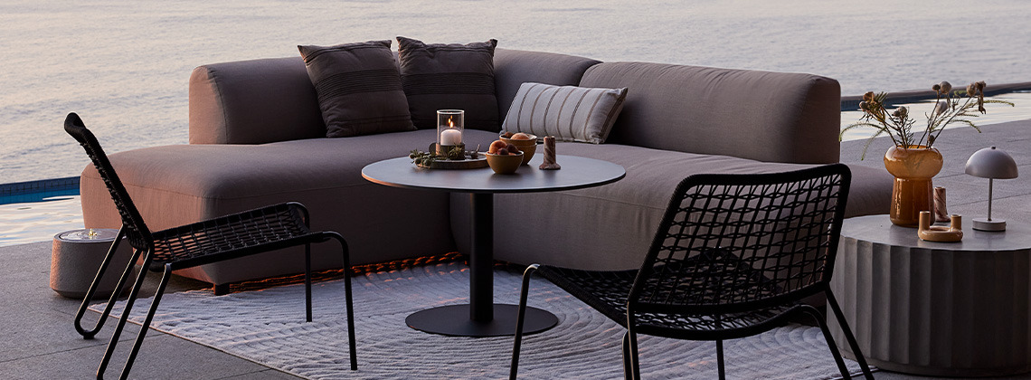Brzosušeća lounge sofa za sve vremenske uvjete i vrtne ležaljke na terasi pri zalasku sunca