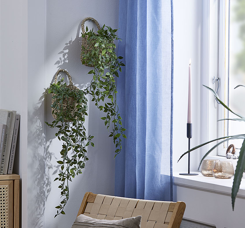 Na zidu dnevne sobe vise dvije košare s umjetnim biljkama