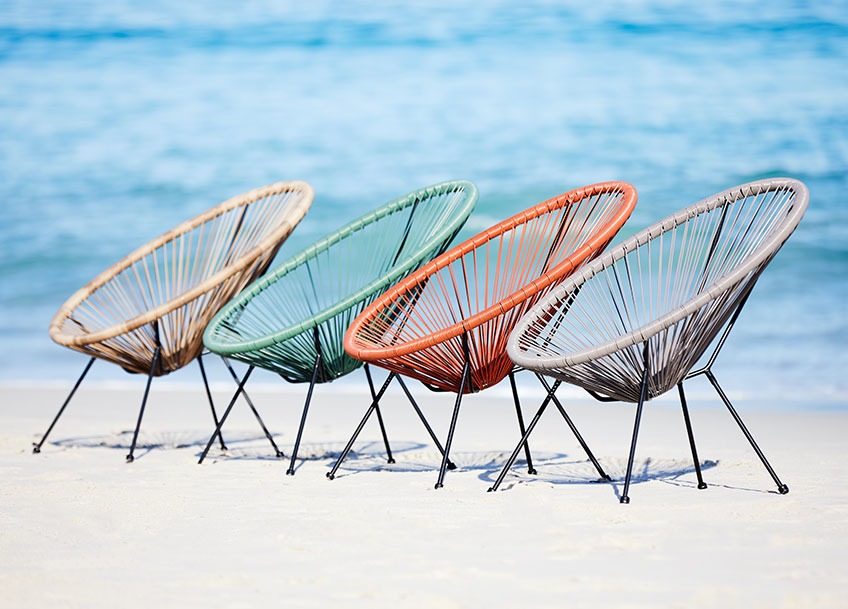 Četiri lounge vrtne stolice u raznim bojama na plaži