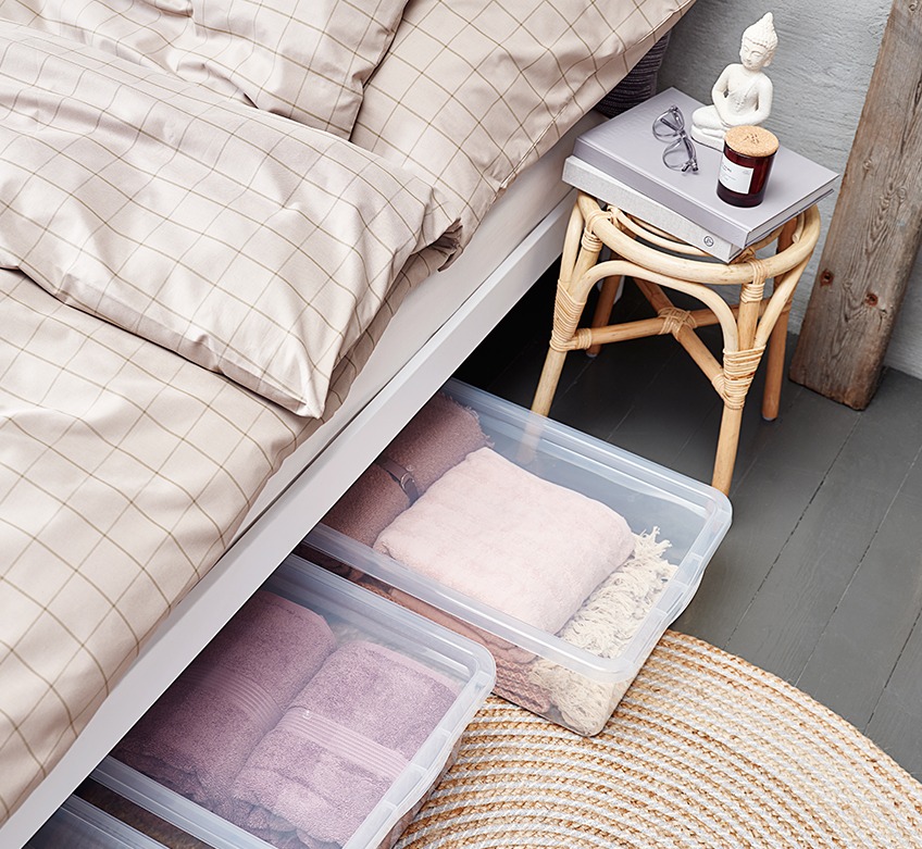 Krevet s bež posteljinom i kutijama za ispod kreveta