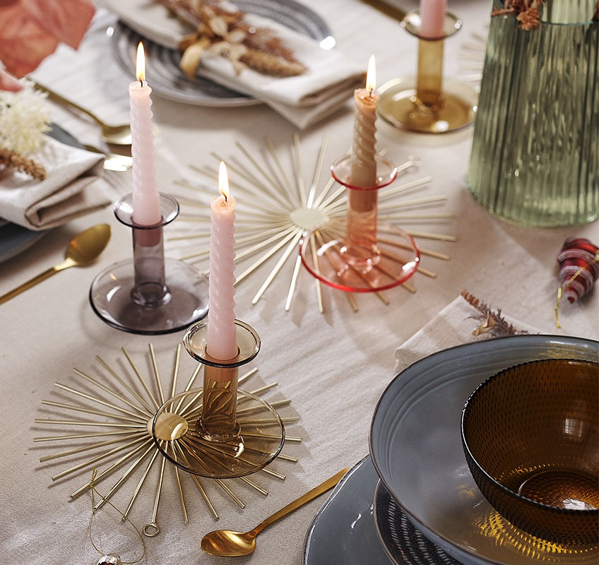 Zlatni ukrasi, svijećnjaci i svijeće na novogodišnjem stolu