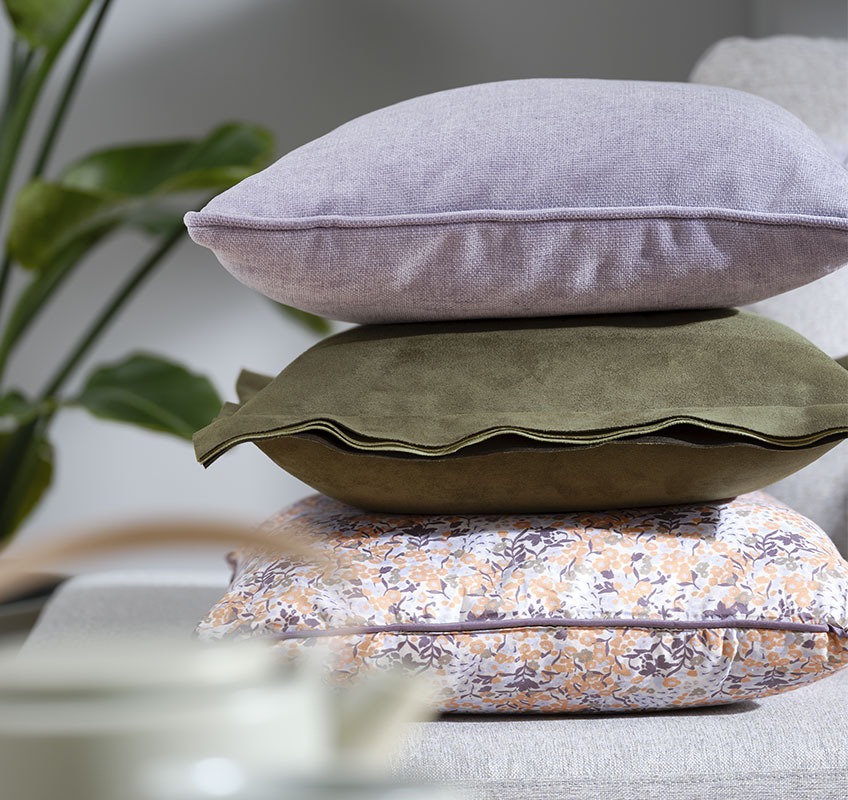 Tri jastuka: jednan ljubičasti, jednan zeleni i jednan s cvjetnim printom