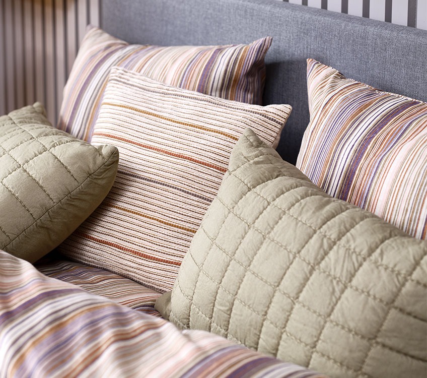 Prugasta posteljina s prugastim ukrasnim jastucima i zelenim jastucima