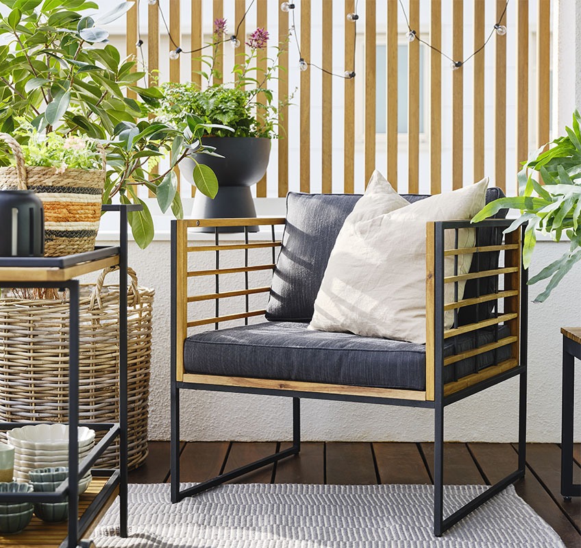 Drvena lounge stolica i crno-zelenim biljkama