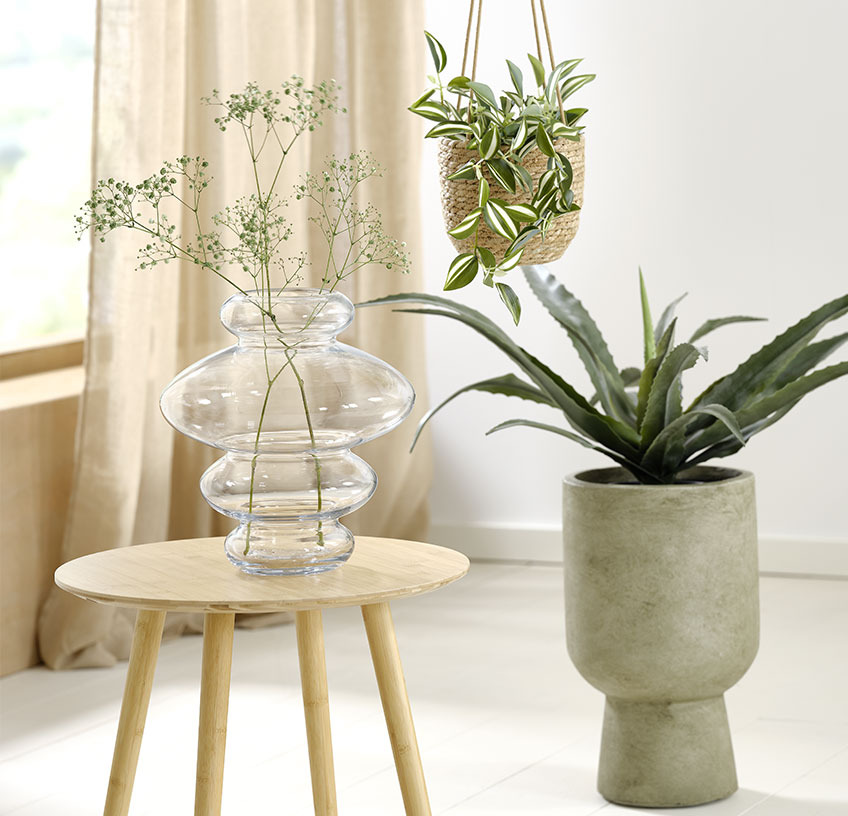 Staklena vaza na stoliću, viseća tegla za cvijeće i zelena posuda za biljke s umjetnim biljkama
