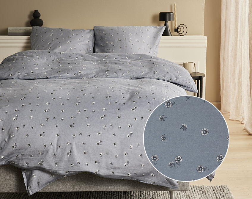 Krevet sa satenskom posteljinom s cvjetićima na tamno sivoj pozadini