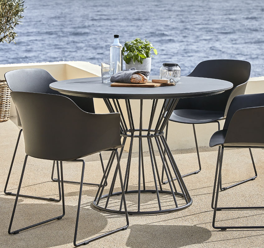 Round garden table in metal and fibre cement and four garden chairs 