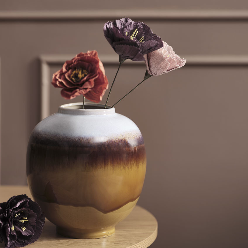 Vaza u nekoliko boja s umjetnim cvijećem u raznim bojama