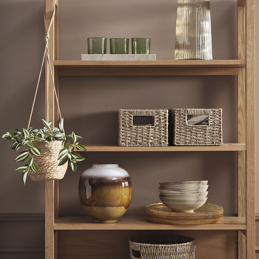 Flowerpot with plant and shelving unit in wood with boxes, tealight holders, vases and other decorations