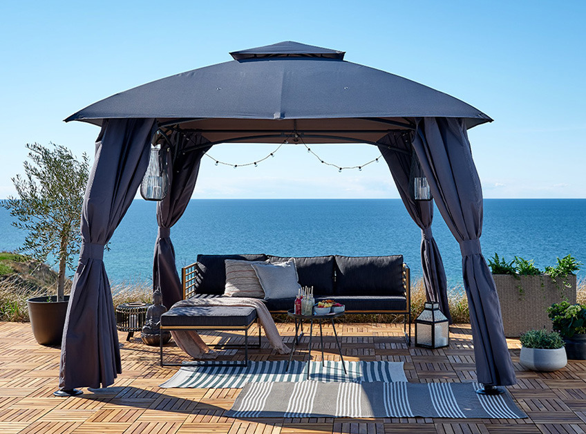 Sivi paviljon s lounge setom i dekoracijama na terasi kraj mora