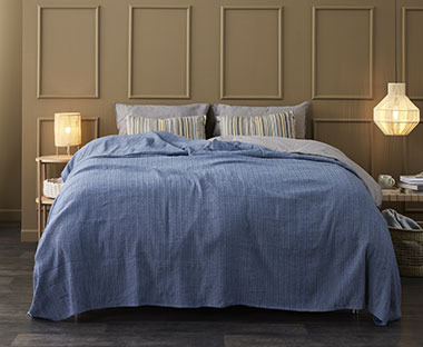 Plavi prekrivač na dvostrukom krevetu
