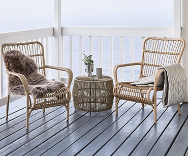 Dvije lounge stolice i stolić na terasi na moru