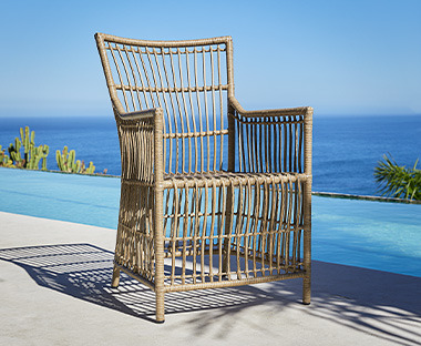 Smeđa vrtna stolica na terasi uz more