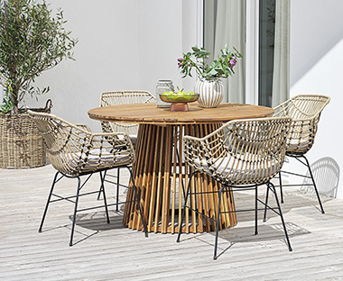 Drveni okrugli stol i 4 pletene stolice na terasi